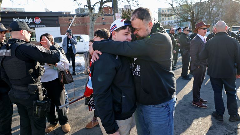 A father hugs his son outside of the Dennis M. Lynch Arena. Pic: AP