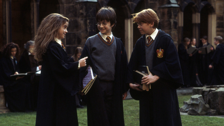 Hermione, Harry, and Ron in the Hogwarts courtyard in Harry Potter and the Sorcerer's Stone