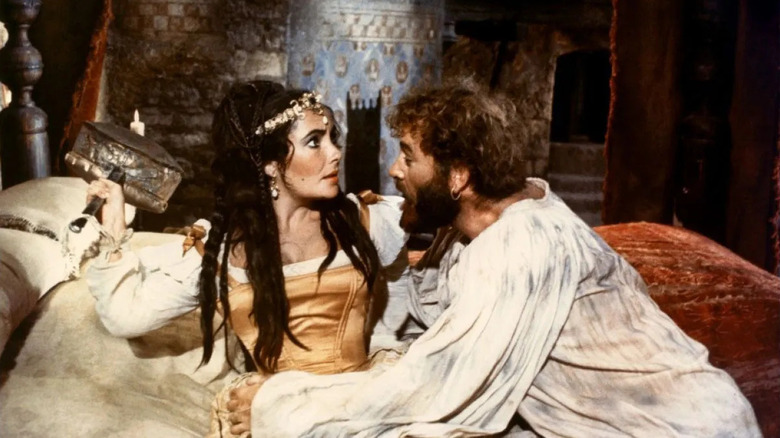 Kate in bed with Petruchio leaning on her in The Taming of the Shrew