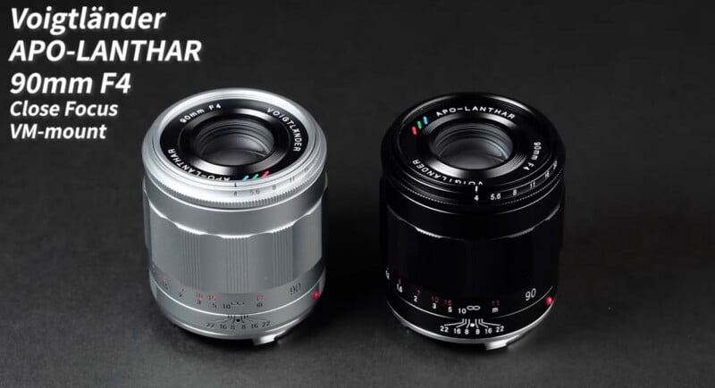Two Voigtländer APO-LANTHAR 90mm F4 VM-mount camera lenses, one silver and one black, are placed side by side on a dark surface. White text labels their model and features in the top left corner.