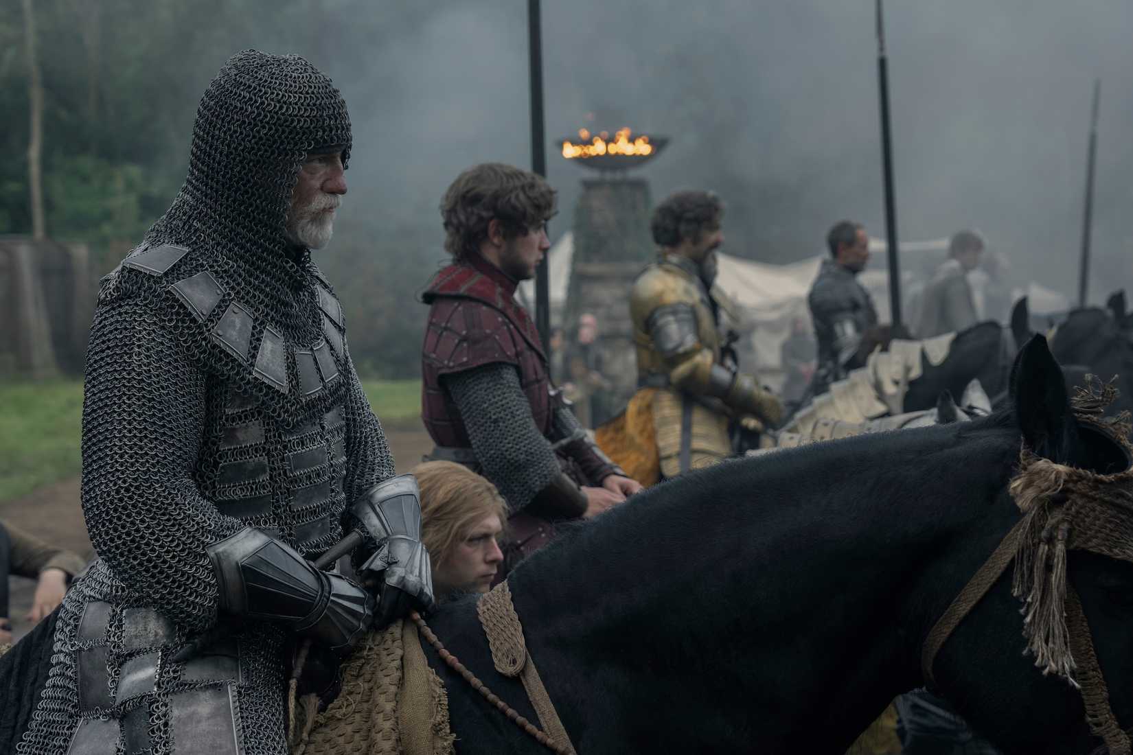 A row of weary, grim, or worried looking knights on horseback and squires standing beside them before a combat in A Knight of the Seven Kingdoms
