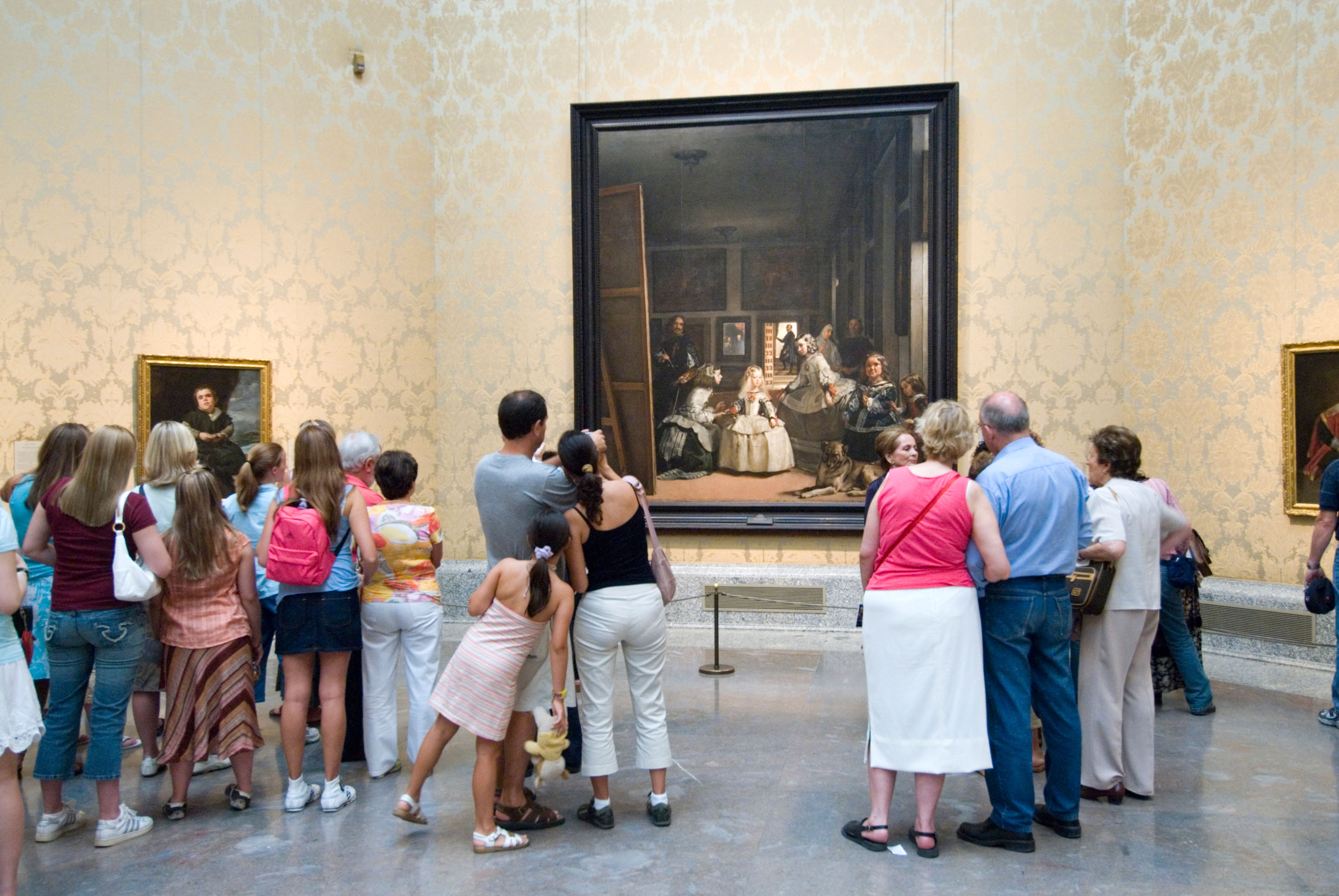 People viewing Diego Velázquez's painting "Las Meninas" in the Museo del Prado.