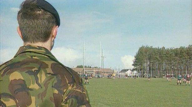 A british soldier observes a gaelic football match