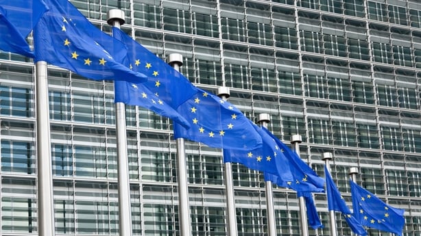 Picture of the outside of the European Parliament with EU flags outside