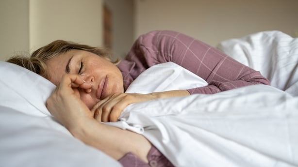 Mature woman in depression lying in bed covered with blanket
