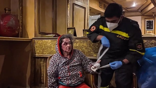 This frame grab from AFPTV video footage taken on March 4, 2026 shows a wounded woman receiving medical treatment