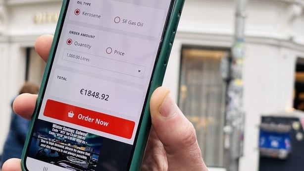 A phone screen shows the price of a fill of oil