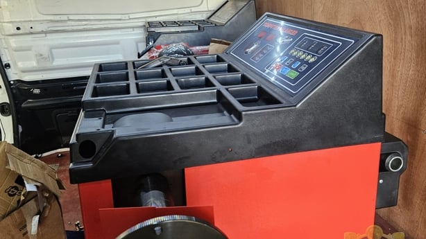 a black and red coloured wheel alignment machine