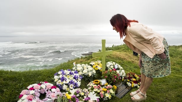 Mary Hornsey, mother of Paul Maxwell, reading the memorial cards after a service to her son