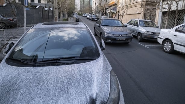 A vehicle is covered with oil-soot residue from Tehran's petroleum storage facilities, which are struck during a US-Israeli military campaign.