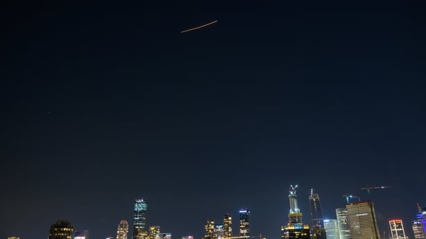 An incoming Iranian missile is seen in the sky over Tel Aviv.