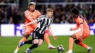 NEWCASTLE UPON TYNE, ENGLAND - MARCH 10: Lewis Hall of Newcastle United is challenged by Ronald Araujo and Lamine Yamal of FC Barcelona during the UEFA Champions League 2025/26 Round of 16 First Leg match between Newcastle United FC and FC Barcelona at St
