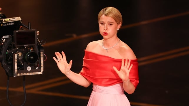 Irish actress Jessie Buckley reacts as she arrives to accept the award for Best Actress in a Leading Role for "Hamnet" onstage during the 98th Annual Academy Awards