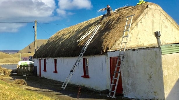 Re-thatching of a cottage at The Doagh Famine Village on a sunny day