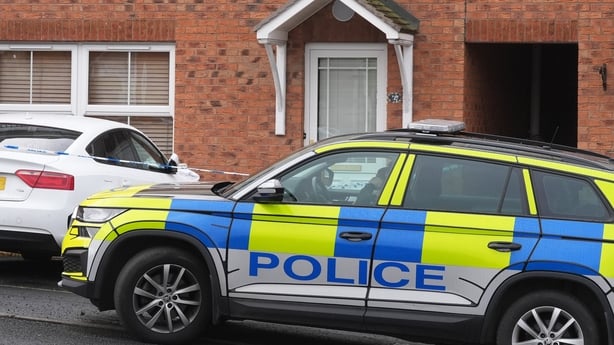 Police cars outside a redbrick house