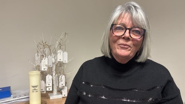 Laura O'Brien sits in front of a table.