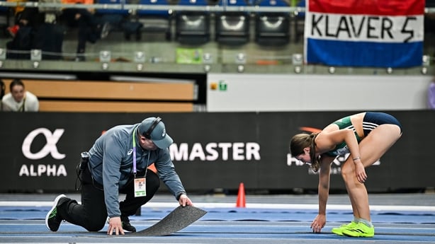 22 March 2026; Kate O'Connor of Ireland assists officials to repair the track before competing in the Women's high jump event in the Women's Pentathlon during day three of the World Athletics Indoor Championships at Kujawsko-Pomorska Arena in Torun, Poland. Photo by Sam Barnes/Sportsfile