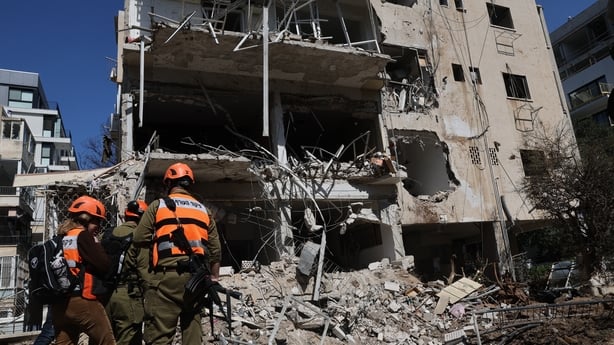 Israeli emergency service personnel gather at the site of an Iranian missile strike in Tel Aviv