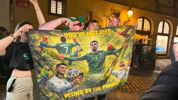 people hold a flag which has troy parrott on it 