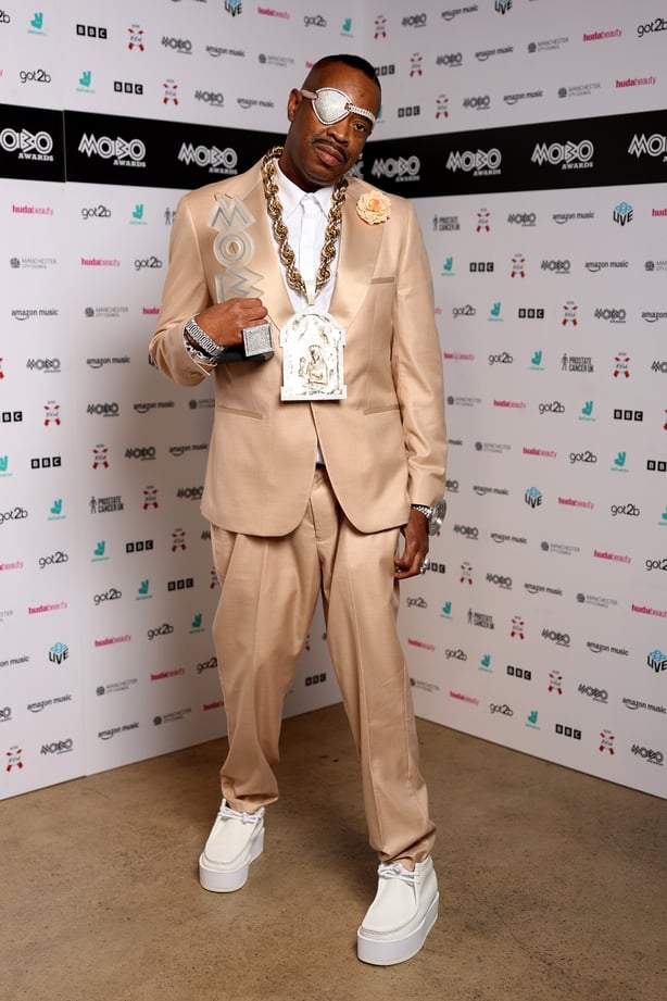 MANCHESTER, ENGLAND - MARCH 26: Slick Rick poses with the award for the MOBO Lifetime Achievement Award inside the winners' room during the 2026 MOBO Awards at Co-op Live on March 26, 2026 in Manchester, England. (Photo by Shane Anthony Sinclair/Getty Images for MOBO)