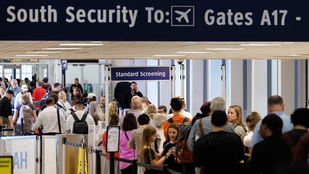 People stand in a long queue at an airport in Washington