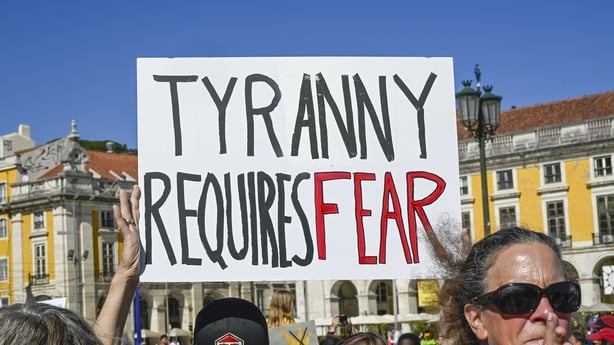 LISBON, PORTUGAL - MARCH 28: U.S. nationals residing in Portugal hold placards while gathering in Praça do Comercio at a protest organized by American activists living in Portugal, during a 