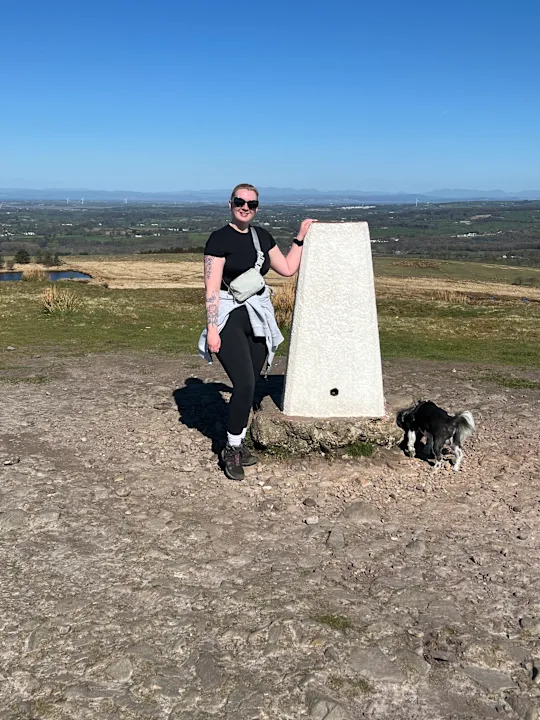 Katie next to a monument on a hill