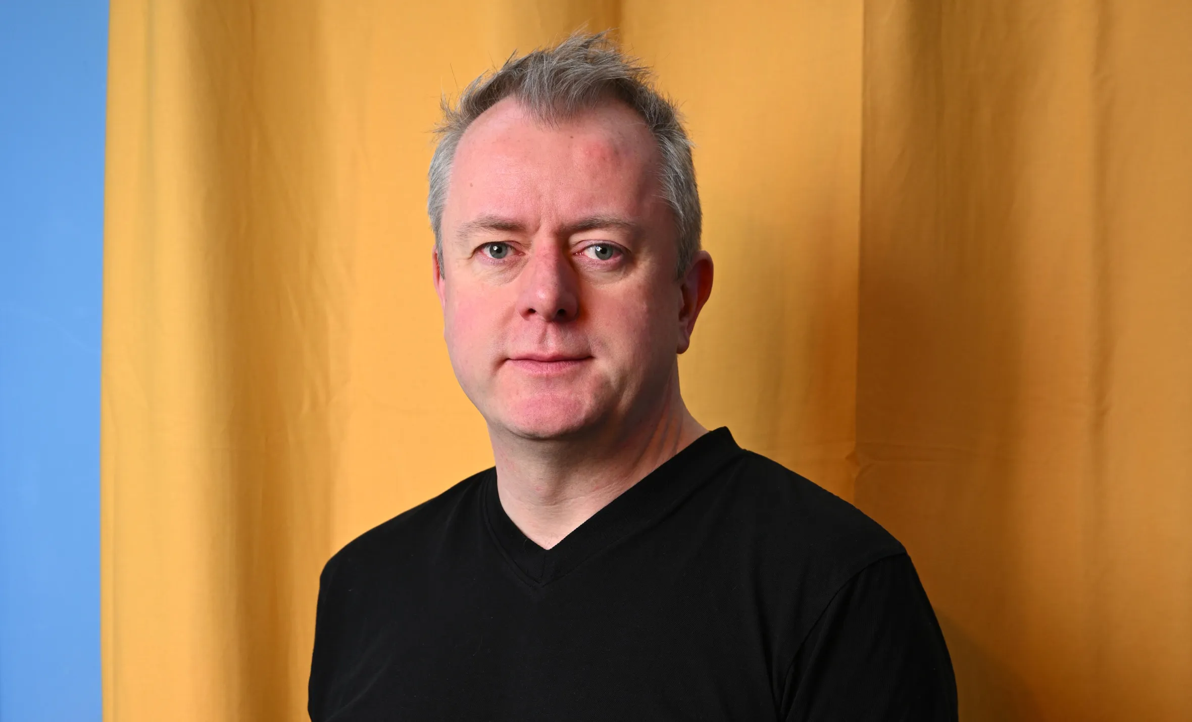 Sean Blanchfield, CEO of Gentic, wearing a black V-neck shirt and blue jeans, with hands in pockets.