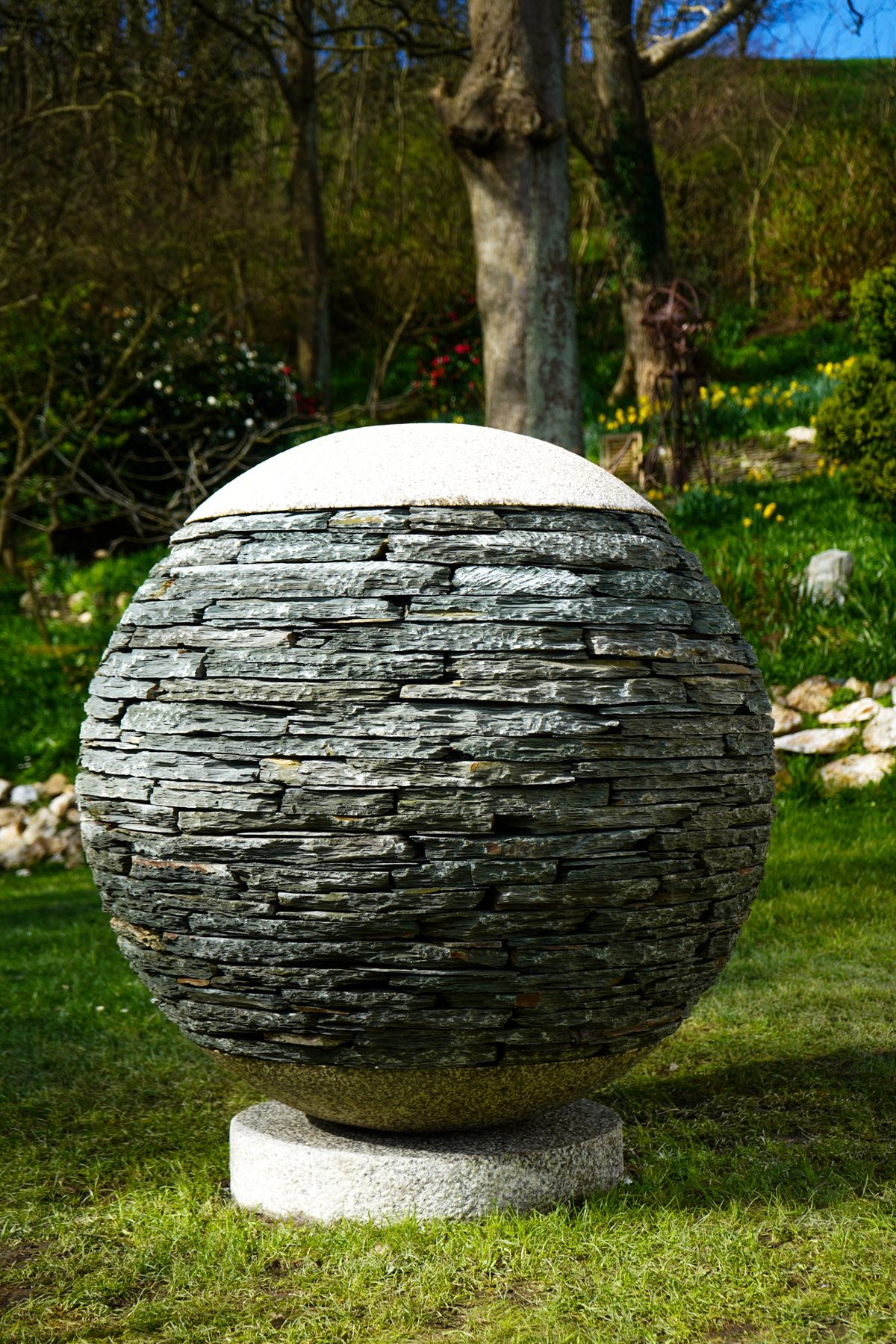 His latest work is a huge stone sphere with a granite base and top and pizza-shaped slate in between 