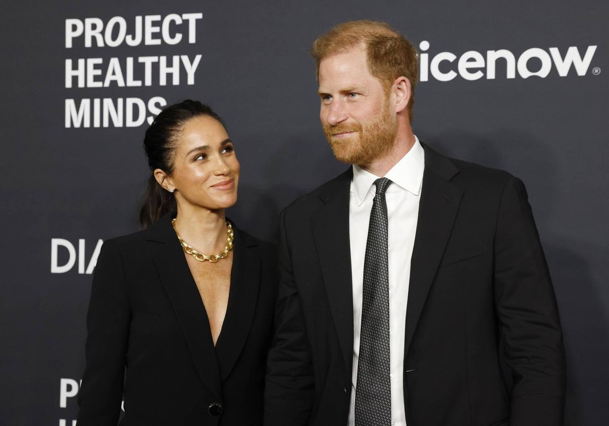 An adult male and female are standing close to each other, likely attending an event. They are dressed formally and appear to be posing for a photograph in front of a backdrop with the text "PROJECT HEALTHY MINDS."