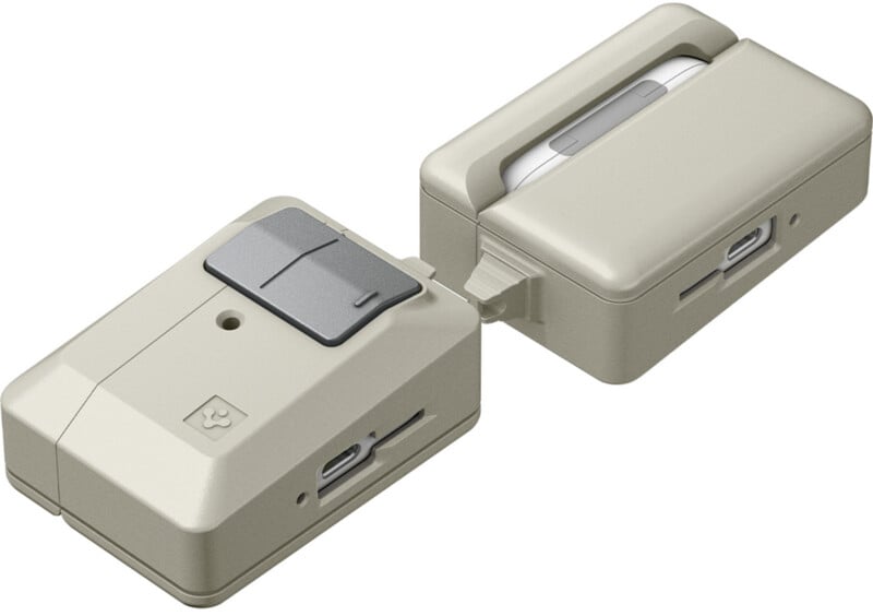 Two compact, beige electronic devices connected by a hinge, each featuring ports, slots, and buttons, with a minimalist design and gray accents.