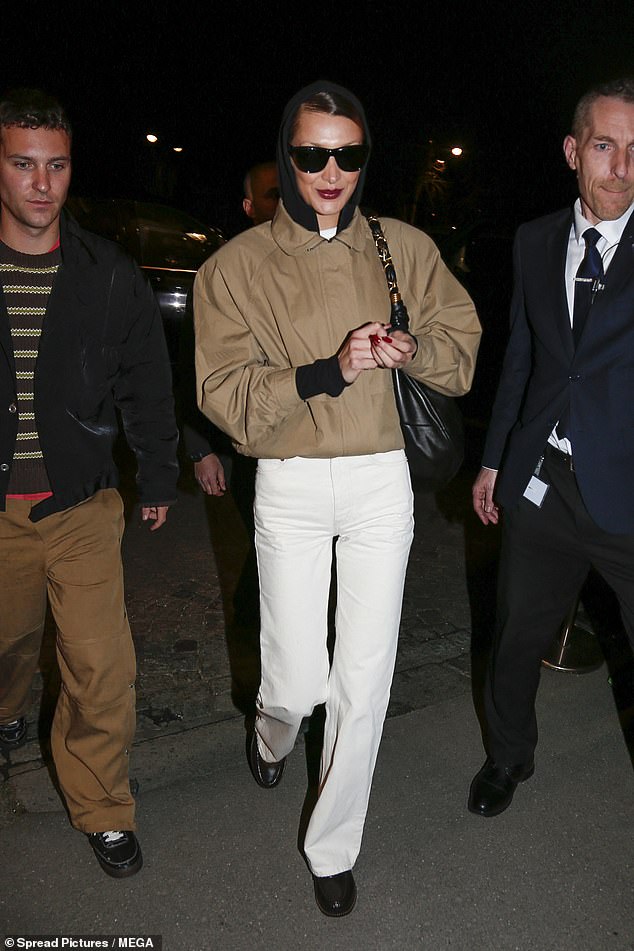The catwalk favourite, 29, cut a casual yet stylish figure in white jeans and a beige bomber jacket for the outing