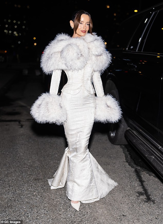 The Love Island icon, 35, showed off her tiny figure in the white floor-length number which boasted a dramatic fur collar and matching cuff sleeves