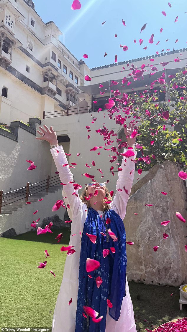During the day, Trinny was seen throwing pink flowers up into the air as she let her hair down and wore her blue scarf around her neck