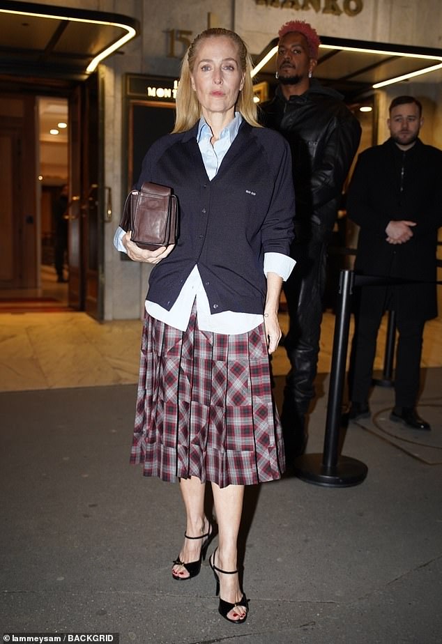 Gillian Anderson cut a sophisticated figure in a pleated checked red knee-length skirt which she teamed with a blue shirt