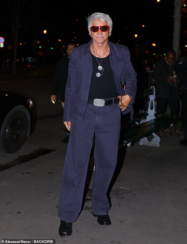 Baz Luhrmann cut a dapper figure in a blue shirt and matching trousers as he posed for photos wearing a pair of red framed sunglasses