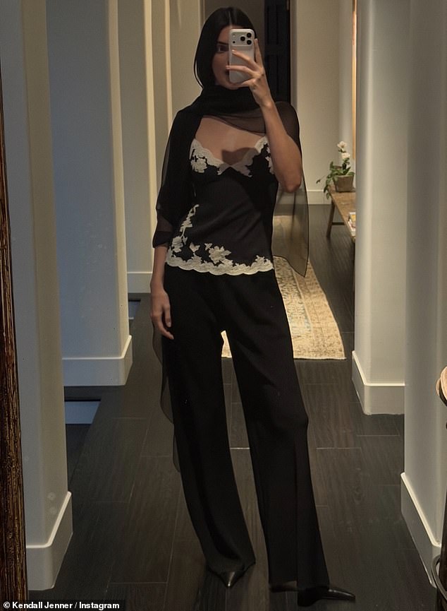 Her black scarf, which appeared to be made of chiffon, was draped over the front of her neck in a retro chic style reminiscent of the 1990s