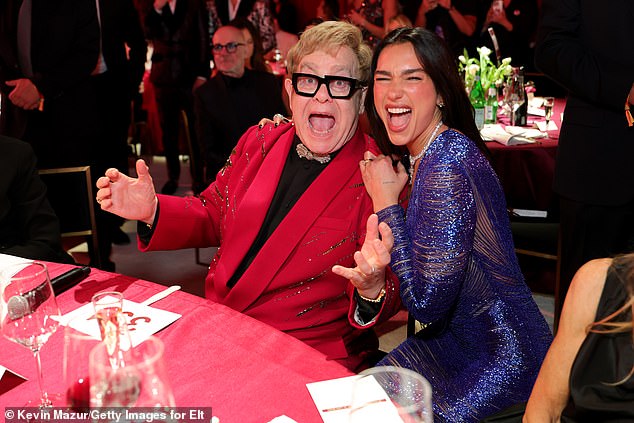The pair posed for spirited snaps together as she prepared to splash the cash during the charity auction