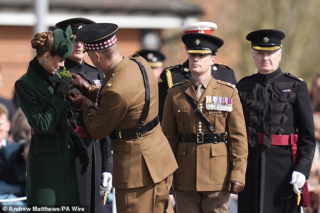 Princess Catherine smiles as she is handed a shamrock at the parade today
