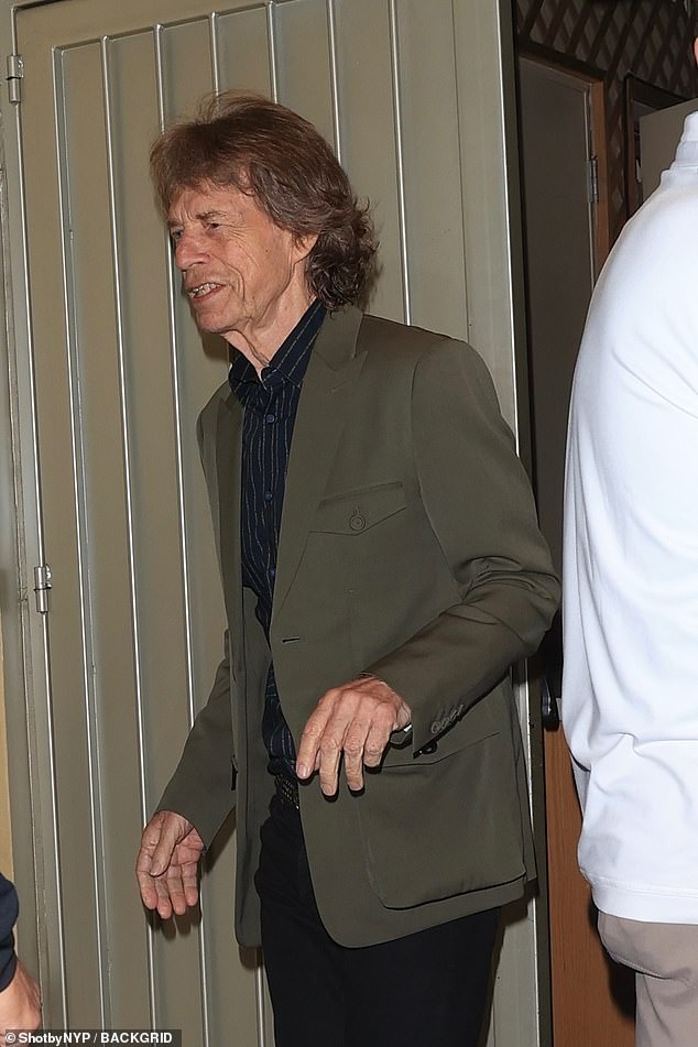 Elsewhere Mick Jagger cut a smart figure in a khaki blazer which he layered over a black striped shirt and suit trousers