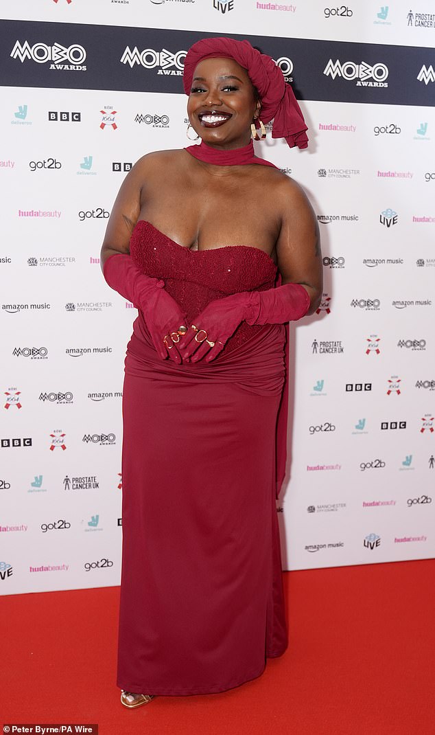 While Misha, 34, stunned in a red strapless gown with a lace-textured bust and matching gloves