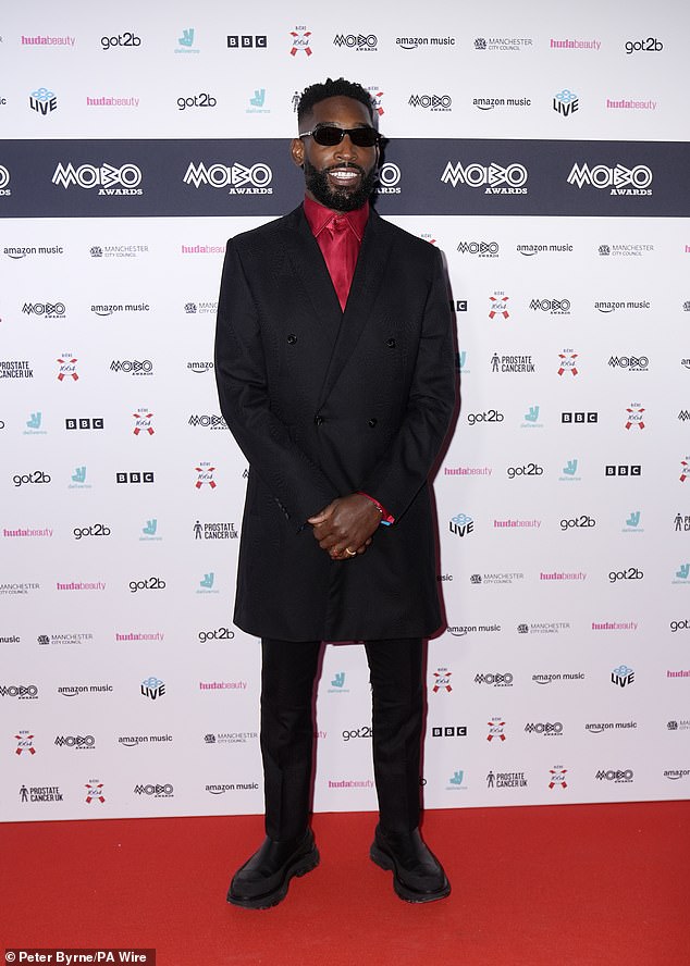 Tinie Tempah looked dapper in a smart black double-breasted coat paired with a vibrant red shirt