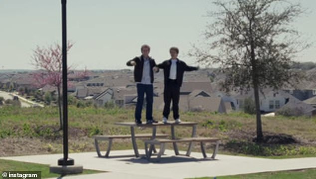 The camera panned back to show the two stars standing on a park bench overlooking a suburban community
