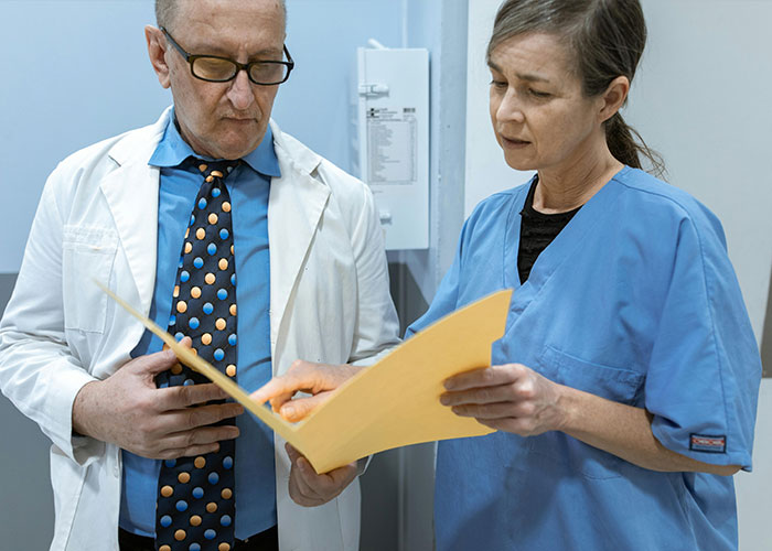 Two medical professionals reviewing patient records, highlighting dark medical secrets and challenges in healthcare.