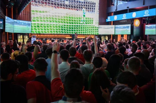 Fans watch football on a massive 4K screen alongside other smaller screens. Pitcture: The Camden