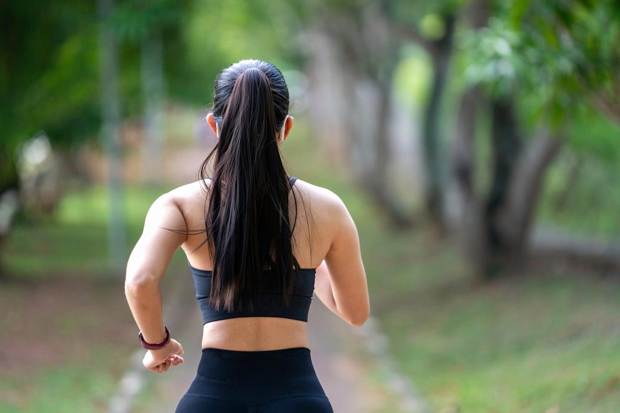back view of young fitness sports women runner running in the park. healthy fitness woman jogging outdoors. sport and health concept