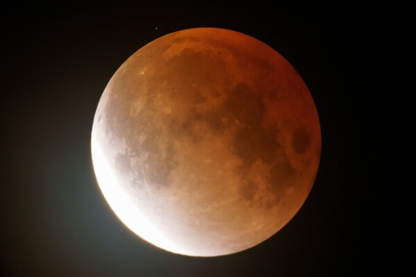 The full Worm Moon glows orange as it begins to emerge from totality during a lunar eclipse in the early morning hours of Tuesday, March 3, 2026, near Moscow, Idaho. (AP Photo/Ted S. Warren)