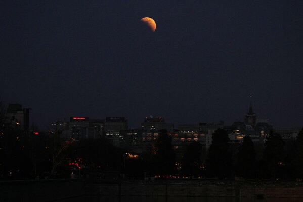 The moon is seen shortly before total lunar eclipse above office buildings in Beijing, China, Tuesday, March 3, 2026. (AP Photo/Andy Wong)
