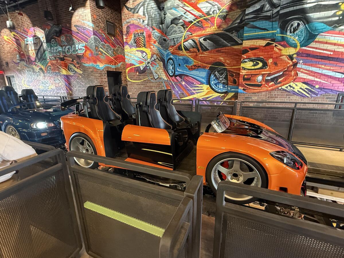A look at the ride vehicles and inside mural in the passenger load area of Fast & Furious: Hollywood Drift.