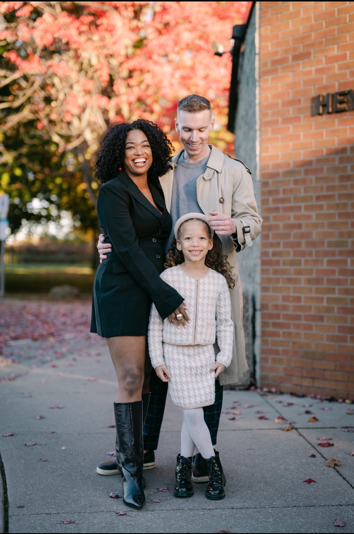 A man, woman and young child posing together for a picture. 